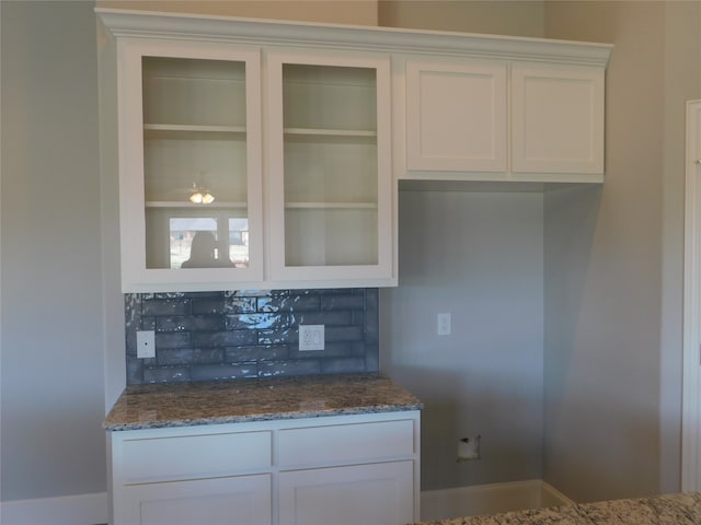 kitchen featuring white cabinets, tasteful backsplash, and stone countertops