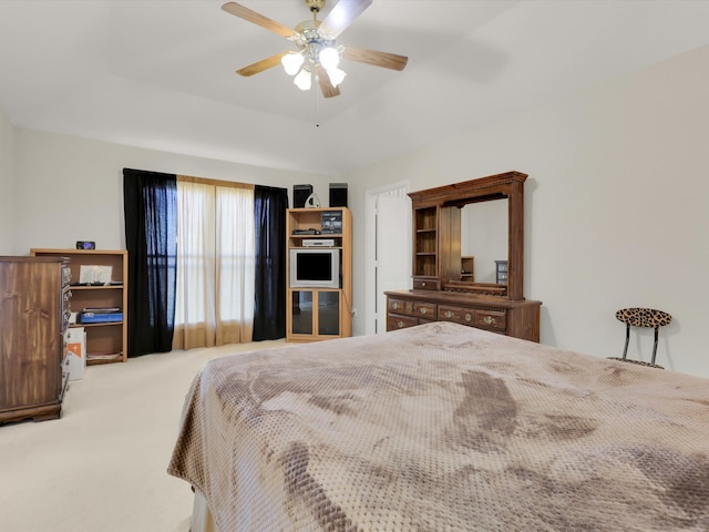 bedroom with ceiling fan, carpet floors, and vaulted ceiling