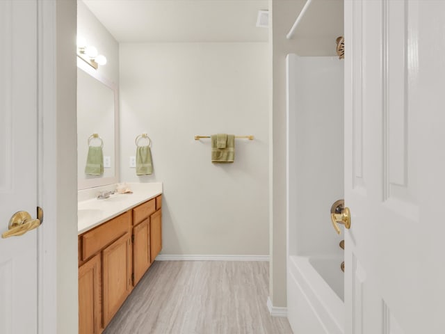 bathroom with vanity, hardwood / wood-style floors, and shower / bath combination