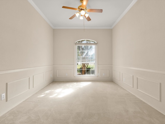 spare room featuring light carpet, ceiling fan, and ornamental molding