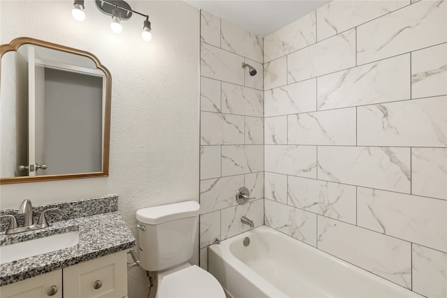 full bathroom featuring tiled shower / bath, vanity, and toilet