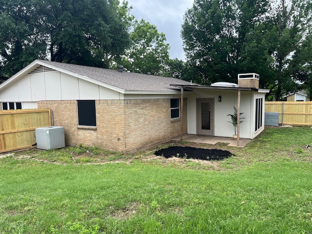 511 Shenandoah Ct, Duncanville, TX 75137 - back of house featuring fence, roof with shingles, brick siding, cooling unit, and a lawn