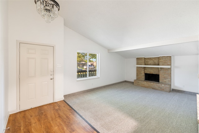 unfurnished living room with wood-type flooring, a fireplace, and lofted ceiling