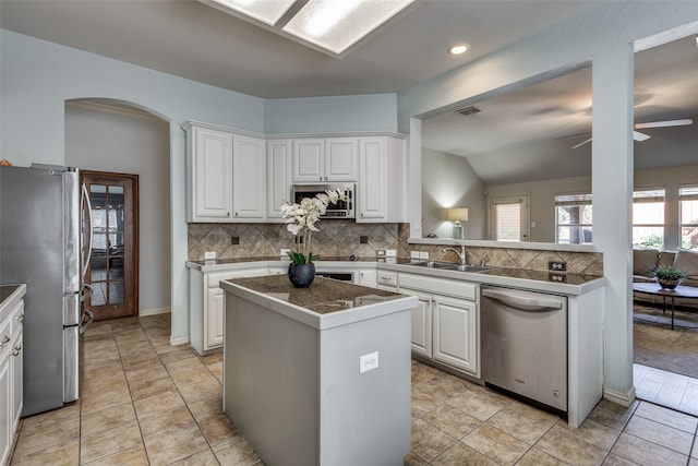 kitchen featuring white cabinets, ceiling fan, stainless steel appliances, sink, and a center island