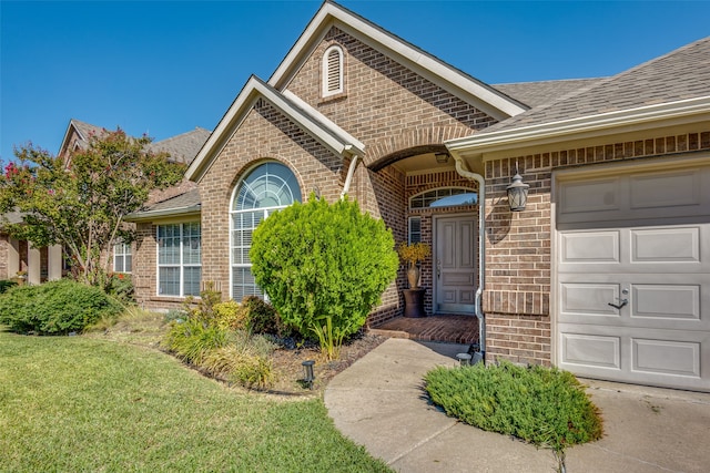 doorway to property with a yard and a garage