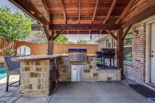 view of patio / terrace featuring area for grilling, a bar, and a grill