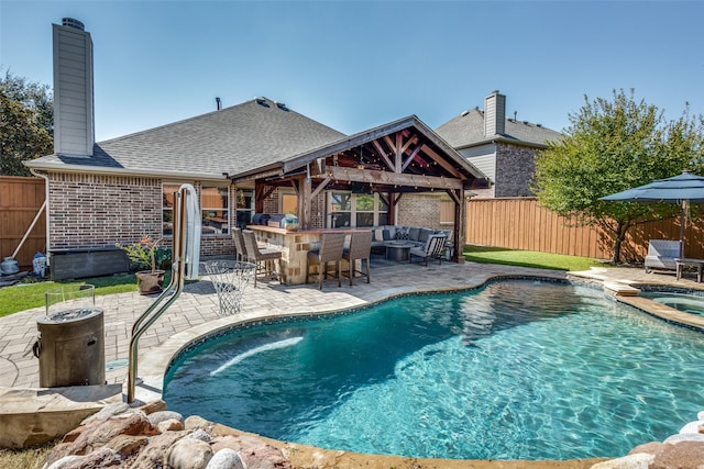 view of pool featuring an in ground hot tub, a patio, a gazebo, an outdoor bar, and an outdoor living space