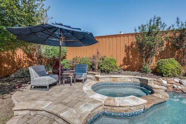 view of swimming pool featuring a patio and an in ground hot tub