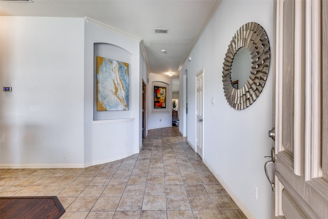 hall with ornamental molding and light tile patterned floors