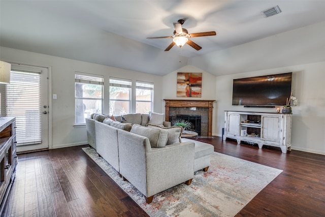 living room featuring lofted ceiling, a tiled fireplace, dark hardwood / wood-style floors, and ceiling fan