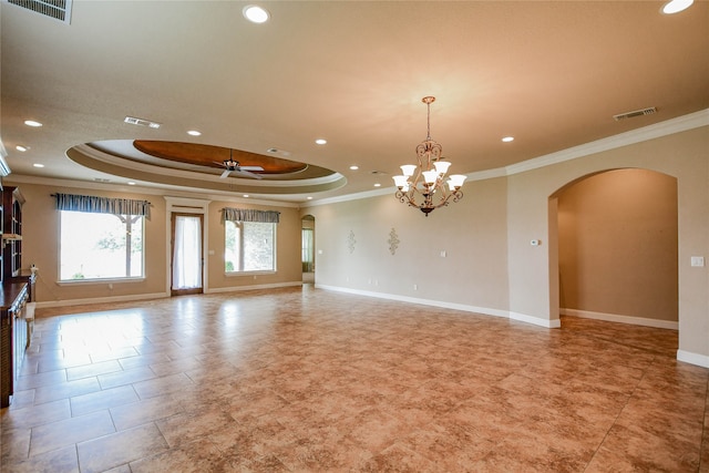 empty room featuring ceiling fan with notable chandelier, a tray ceiling, and ornamental molding