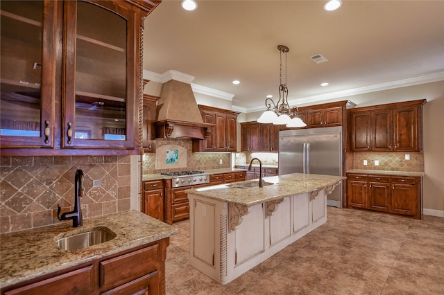 kitchen featuring custom exhaust hood, a kitchen island with sink, hanging light fixtures, and sink