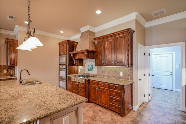 kitchen featuring pendant lighting, custom exhaust hood, sink, ornamental molding, and appliances with stainless steel finishes