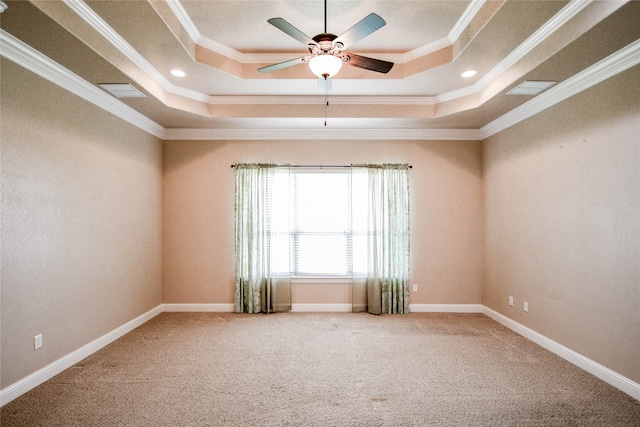 carpeted empty room with a tray ceiling, ornamental molding, and ceiling fan