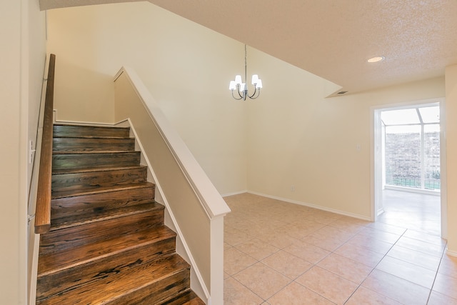 stairs featuring vaulted ceiling, tile patterned flooring, a textured ceiling, and a notable chandelier