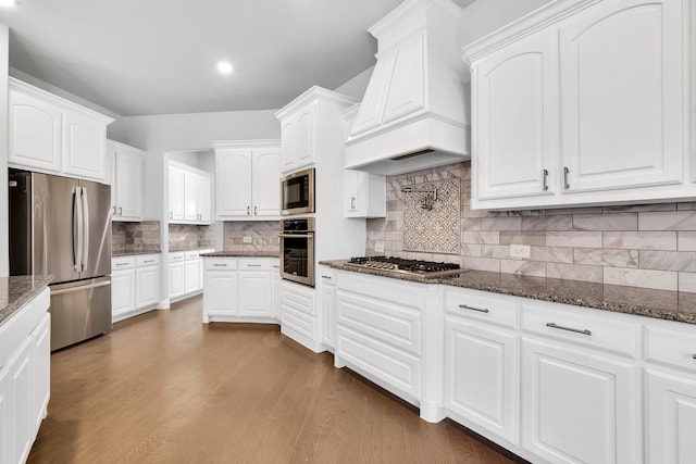 kitchen featuring dark hardwood / wood-style floors, white cabinets, custom exhaust hood, backsplash, and appliances with stainless steel finishes