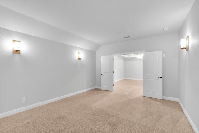 unfurnished room featuring light colored carpet and lofted ceiling