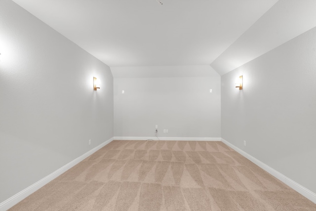 carpeted empty room with lofted ceiling