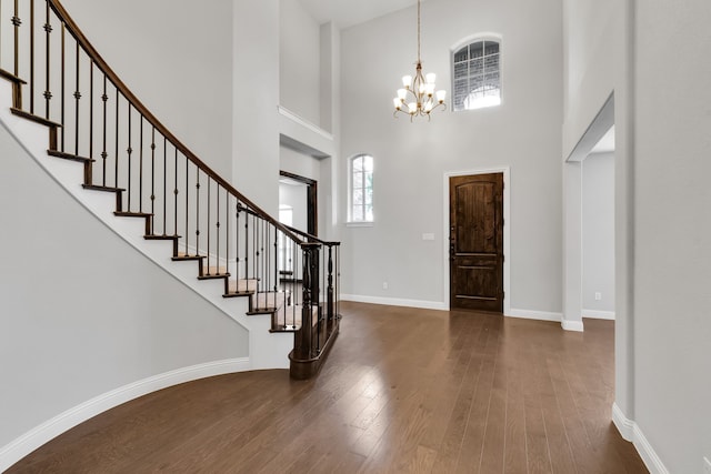 foyer entrance with an inviting chandelier, a high ceiling, and dark wood-type flooring