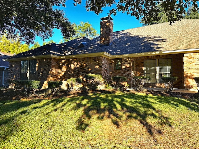 rear view of property with a lawn