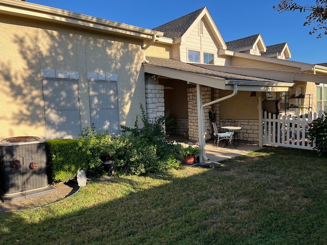 back of property featuring cooling unit, a yard, and a patio