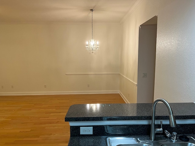 interior space featuring sink, decorative light fixtures, a chandelier, hardwood / wood-style flooring, and crown molding