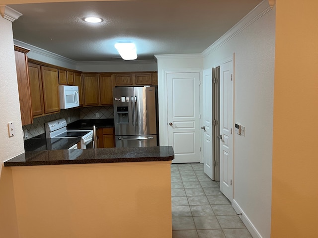 kitchen with kitchen peninsula, decorative backsplash, white appliances, light tile patterned floors, and ornamental molding