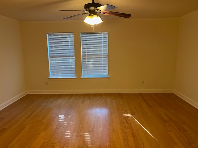 spare room featuring ceiling fan, hardwood / wood-style flooring, and crown molding