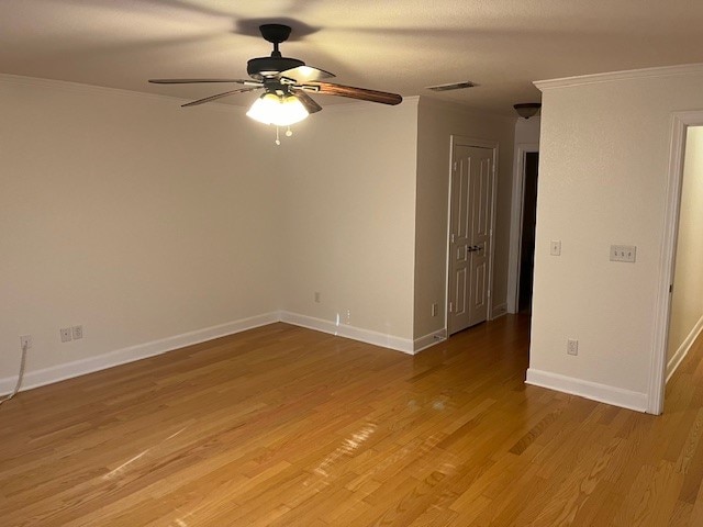 spare room with ceiling fan, light wood-type flooring, and crown molding