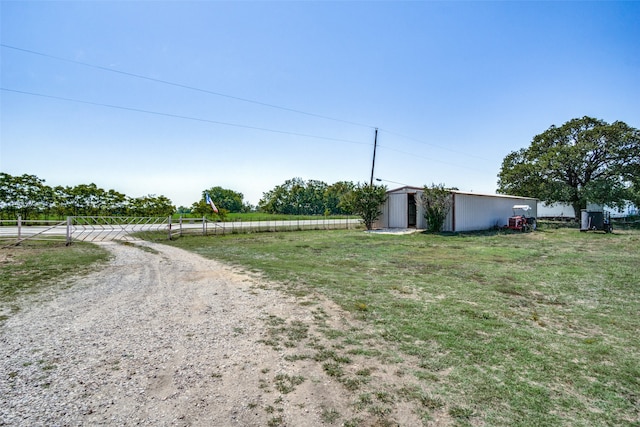 view of yard featuring an outdoor structure and a rural view