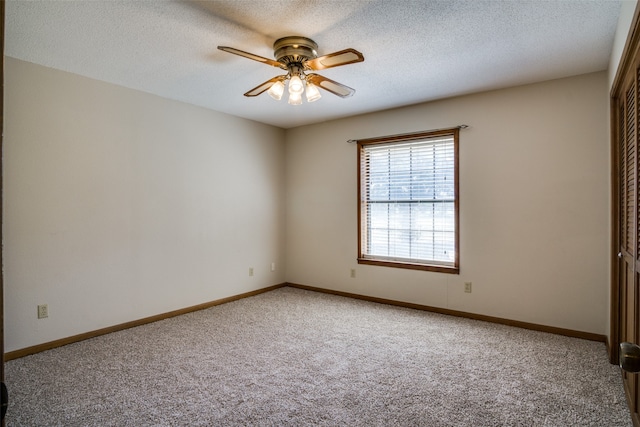 empty room with a textured ceiling, carpet floors, and ceiling fan