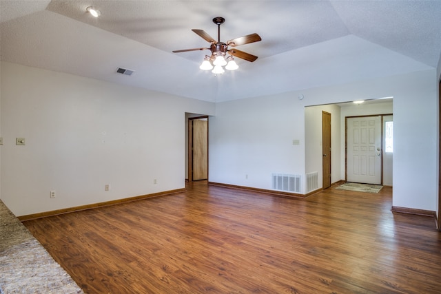 empty room with lofted ceiling, ceiling fan, and dark hardwood / wood-style floors