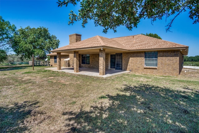 back of house featuring a patio and a yard