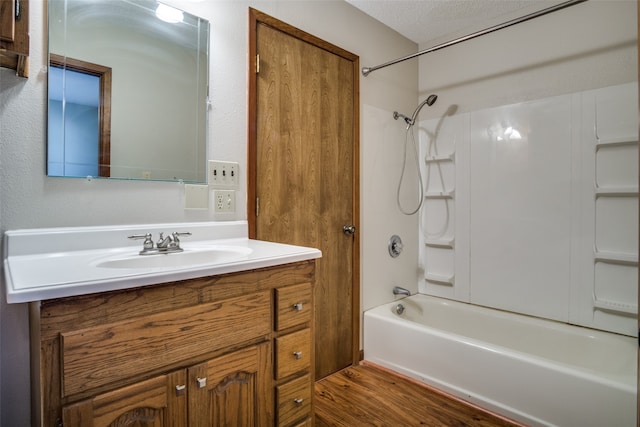 bathroom with vanity, bathing tub / shower combination, a textured ceiling, and hardwood / wood-style flooring