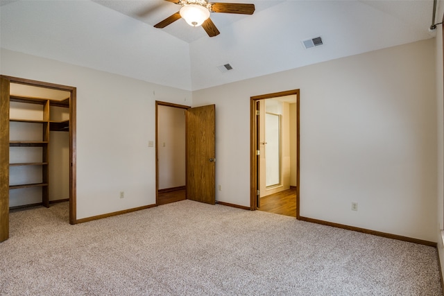 unfurnished bedroom with ceiling fan, light colored carpet, a closet, and a walk in closet