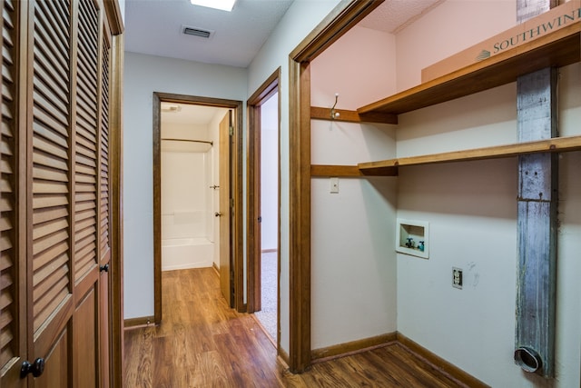 clothes washing area with washer hookup, a textured ceiling, and dark hardwood / wood-style floors