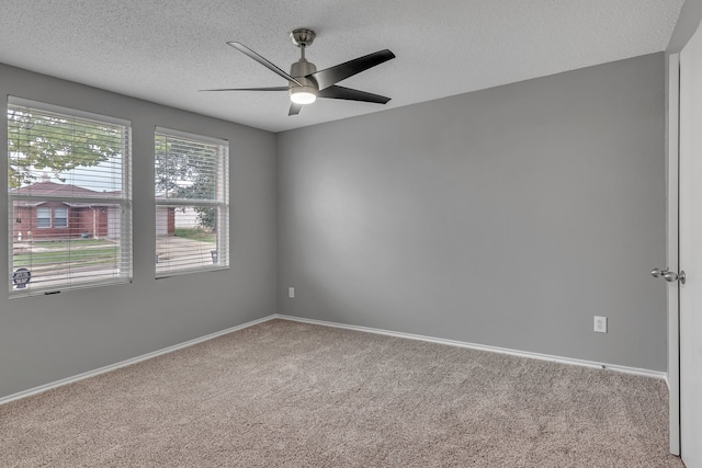 spare room featuring ceiling fan, carpet floors, and a textured ceiling