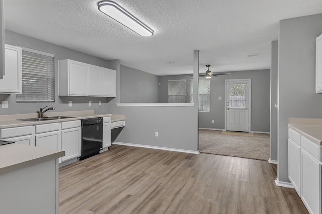 kitchen with black dishwasher, sink, white cabinetry, light hardwood / wood-style flooring, and ceiling fan