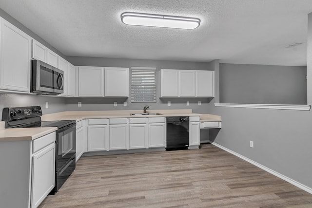 kitchen featuring light wood-type flooring, a textured ceiling, sink, white cabinets, and black appliances