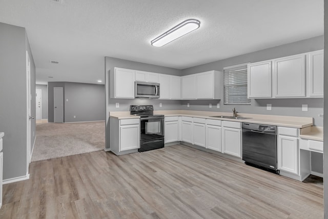 kitchen with white cabinets, a textured ceiling, black appliances, light hardwood / wood-style flooring, and sink