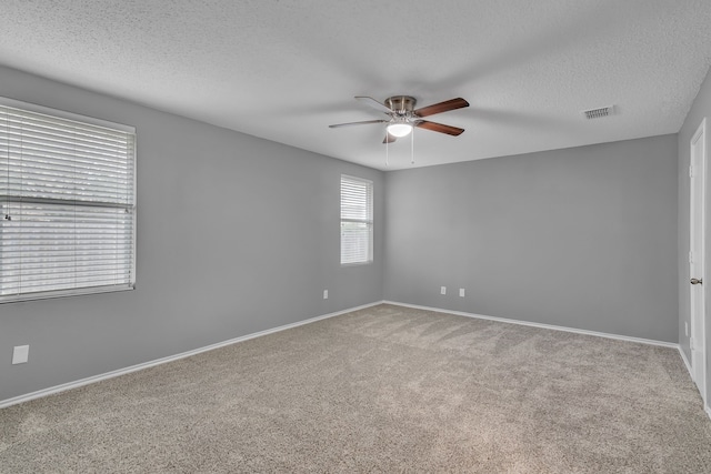 spare room with carpet, ceiling fan, and a textured ceiling