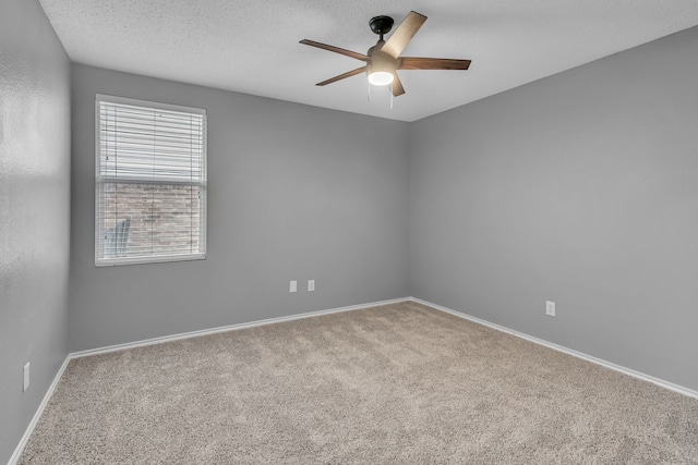 spare room with ceiling fan, a textured ceiling, and carpet flooring