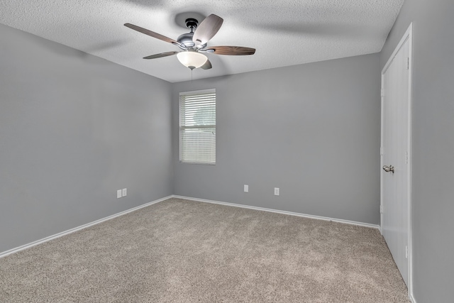 unfurnished room featuring light carpet, ceiling fan, and a textured ceiling