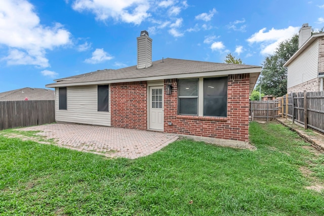 back of property with a patio and a yard