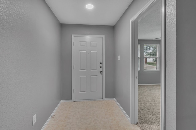 doorway to outside with light carpet and a textured ceiling