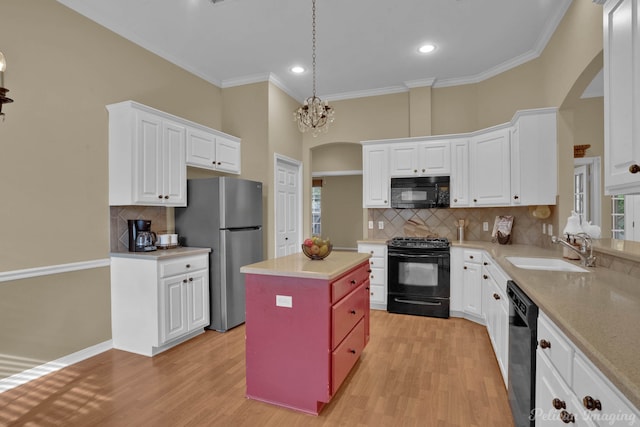 kitchen featuring a kitchen island, white cabinetry, black appliances, light hardwood / wood-style floors, and sink