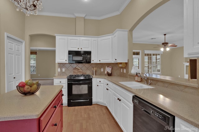 kitchen with black appliances, sink, ceiling fan with notable chandelier, light hardwood / wood-style floors, and crown molding