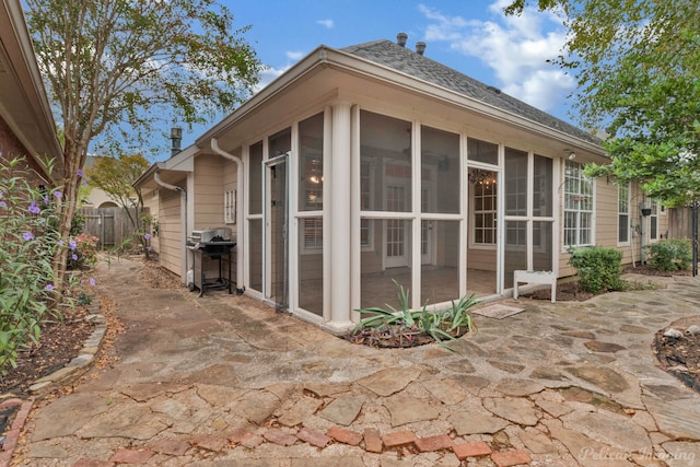 view of side of property with a patio area and a sunroom