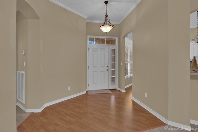 entrance foyer with crown molding and light hardwood / wood-style flooring