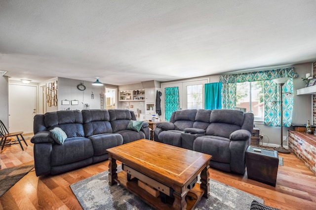 living room with a textured ceiling and light hardwood / wood-style floors